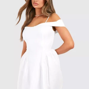 Vit axelbandslös klänning - Säljer en snygg vit klänning med offshoulder och smala axelband.  Var tänkt att ha som studentklänning men var för liten. Köpt för 600kr lappen kvar