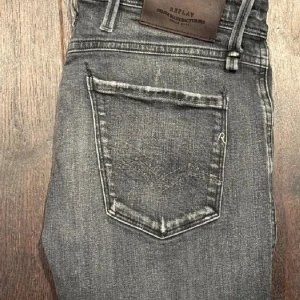 Replay grå jeans - Snygga grå jeans från Replay med slitningar och klassisk femficksdesign. Jeansen har Replay-logga på fickan och läderpatch bak i midjan. Perfekta för en avslappnad och trendig look. Nypris 1800 kr.