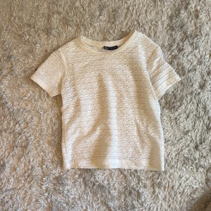 Vit spetsmönstrad t-shirt från Zara - Säljer en vit t-shirt från Zara i storlek S. Toppen har ett fint spetsmönster och är tillverkad i ett mjukt material. Perfekt för vår och sommar, med korta ärmar och rund halsringning.
