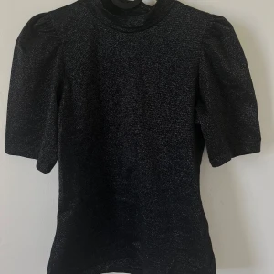 Svart glittrig topp med puffärm - Lite finare glittrig topp, använd endast 1 gång.☺️