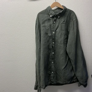 Gant linneskjorta - Säljer en stilren grön gant skjorta i linne. Skjortan har klassisk krage, bröstficka med broderad Gant-logga och vita knappar framtill. Skjortan är i bra skick och är sällan använd. Den har inga defekter. Storlek 158-164cm. Tar ej imot byten. Först till kvarn. Den är perfekt för sommaren. Ostrykt men stryker skjortan vid köp.