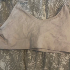 Beige ribbad rib bra från 157 - Säljer en beige ribbad rib bra från 157 i storlek L. Toppen har en enkel och stilren design med bred resår under bysten och är tillverkad i ett mjukt, ribbat material. Perfekt för en avslappnad och bekväm stil.