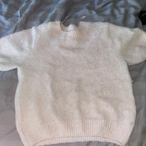 Rosa stickad tröja med kort ärm - Mysig roda stickad tröja med korta ärmar och rund halsringning. Tröjan har en enkel och clean look. Bilden hade inte bra ljus men den är lite mer rosa än så. 