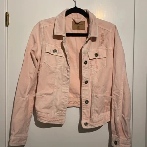  jeansjacka!  - Snygg ljusrosa jeansjacka från Amisu i klassisk modell med knappar framtill och två bröstfickor. Jackan har slitna detaljer för en trendig look och är tillverkad i bomull. Perfekt att slänga över en hoodie eller t-shorts! Jackan är knappt använd, max vid 3 tillfällen. 