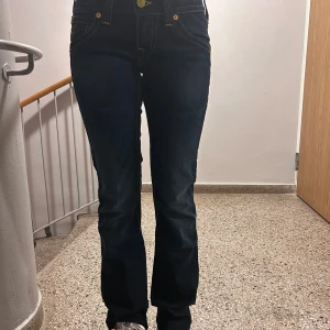 True Religion  - Säljer ett par klassiska True Religion jeans i mörkblå denim med kontrasterande gula sömmar och ikonisk fickdesign. Jeansen har en bootcut modell och är köpte i newyork. Pris kan diskuteras!❤️