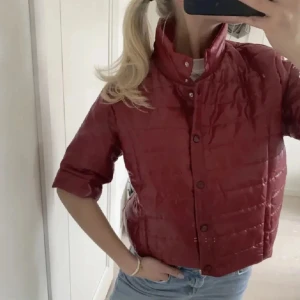Mörkröd quiltad trekvartsärmad jacka - Snygg röd quiltad jacka med trekvartsärm och knappar framtill. Perfekt för en cool och avslappnad stil. Jackan har en croppad passform som ger en modern look. Pris är alltid diskuterbart, framförallt om du köper en bundle🩷