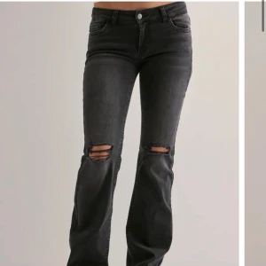 Svarta bootcut jeans med slitningar - Säljer mina super snygga Nelly jeans som inte kommer till användning! Trådarna på knäna har gått av lite men inget man alls tänker på! 💞