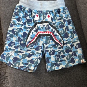 Bape shorts - Ett par bape shorts som jag köpte för två år sedan och bara använda ett par gånger. Dom är i storlek L men kan användas av nästan alla då shortsen anpassar midjan till dig. Jag har s och dom passar mig och min vän som har ett par likadana i samma storlek men vanligt vis har L så passar dom honom också.