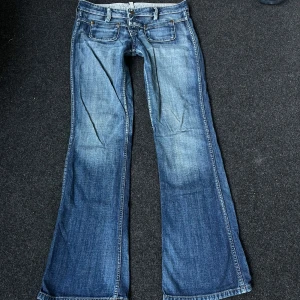 Lowrise Bootcut Jeans - 39cm rakt över midjan, 19,5cm grenhöjd, 23,5cm rakt över benöppningen och 81cm innerben💓 Slitna i grenen men annars i bra skick!😇 Har ingen bild på! 