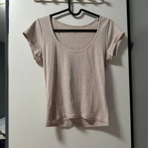 Ljusrosa topp från Brandy Melville - Supersöt ljusrosa topp från Brandy Melville med rundad halsringning och korta ärmar. Toppens kanter har en fin virkad detalj och materialet är mjukt och stretchigt. Perfekt att styla med jeans eller kjol för en chill look. One size men passar xs-s💕