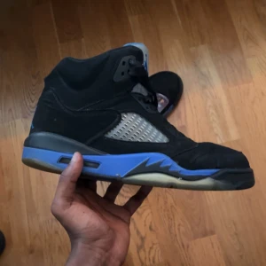 Nike Air Jordan 5 Retro Black/Blue - Hej, Säljer nu ett par Nike Air Jordan 5 Retro svart och blå, storlek 44 men passar också 45. Dom är använda ett par gånger men är bra skick, för mer information skriv😁
