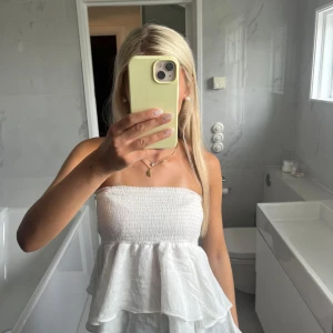 Vit volangkjol med resårmidja - Supersöt vit kortkjol med dubbla volanger och bred smock i midjan. Kjolen är luftig och lätt, perfekt för varma dagar. Går att använda både som kjol och topp!🙌🏼🙌🏼🙏🏼