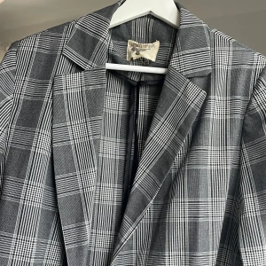 Rutig blazer, Sacred Hawk  - Fantastisk kavaj i längre, oversize modell från Sacred Hawk. Double breasted knäppning med två fickor. Perfekt att använda som kavajklänning eller med en mer edgy outfit. Använd men utan signs of wear. 