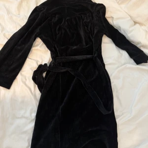 Svart manchesterklänning Odd Molly - Ny! Supersnygg svart manchesterklänning från Odd Molly med knappar hela vägen framtill och tillhörande bälte i midjan. Klänningen har långa ärmar och en cool, lite retro känsla. Perfekt för dig som gillar en klassisk men trendig look.