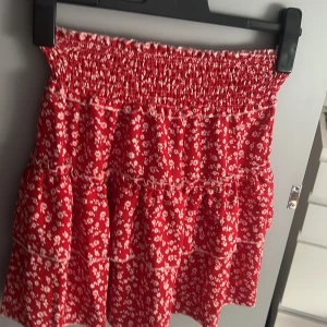 Röd kjol  - Jätte söt röd kjol med vita blommor storlek S