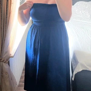 Marinblå  klänning - Snygg marinblå klänning med smock upptill och avtagbara tunna axelband. Använd en gång. 