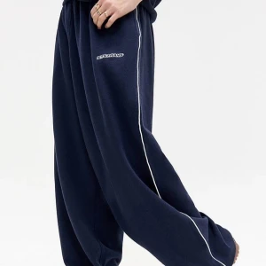 Mörkblå mjukisbyxor från Iets Frans - Mörkblå mjukisbyxor från Iets Frans med vit piping längs sidorna och broderad logga på låret. Byxorna har en loose passform och är tillverkade i mjukt material, perfekta för chill dagar men även dansare. Elastisk midja och avslappnad stil. ‼️Endasr använda 1 gång‼️