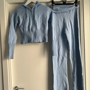 Ljusblå stickade lågmidjade byxor - Säljer ett par ljusblå stickade byxor med låg midja och ribbad kant med spänndetalj. Byxorna är tighta och har en mjuk, stretchig känsla. Perfekta för en chill och trendig look, matcha gärna med en hoodie för en komplett outfit. Catania club Frankie’s bikinis 