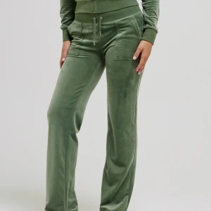 Gröna mjukisbyxor med snörning - Snygga gröna mjukisbyxor i mjuk sammet med raka ben och bred resår i midjan. Byxorna har snörning framtill och stora fickor som ger en chill vibe. Perfekta för att hänga hemma eller dra till stan med kompisarna.