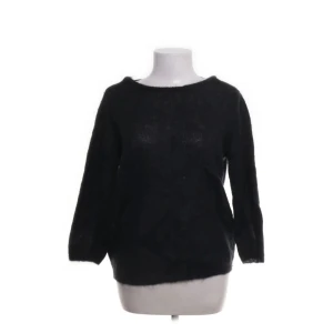 Svart stickad tröja Selected Femme - Svart stickad tröja från Selected Femme i storlek S. Tröjan har lång ärm och en snygg öppen rygg med v-ringad skärning bak. Materialet är en mjuk mix av mohair och ull, vilket gör den fluffig och skön. Perfekt för dig som gillar stilrena och enkla plagg med en twist.