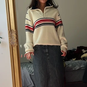Randig half zip tröja från Sprint - Säljer en retro offwhite tröja från Sprint med coola röda och marinblå ränder över bröstet och ärmarna. Tröjan har en hög krage med half zip och är långärmad. Materialet är 100% ull och känns mjukt och skönt mot huden. Perfekt för dig som gillar vintagevibbar!