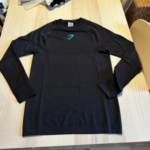 Gymshark Onyx Midnight longsleeve - str M - Säljer min Gymshark Onyx Longsleeve i nyskick. Pris kan diskuteras och kvitto finns.                          ✔️ Original från Gymshark                                     ✔️ Slim fit & stretchigt material                            ✔️ Nyskick utan användning                                 
