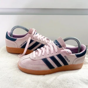 Adidas Spezial rosa sneakers strl 36⅔ - Adidas Spezial sneakers i ljusrosa mocka med mörkblå ränder och detaljer. Snygg gummisula i beige som ger retrovibbar. Klassisk låg modell med snörning och rund tå. Perfekt för dig som gillar streetstyle och vill sticka ut med färg. (Köpte dessa på Vinted men de var för små så jag lånar vinters bilder!, jag har bara använt de en gång!)💕💕