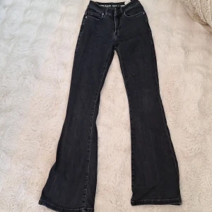 Svarta low flare jeans, midja S - Svarta jeans från Bik Bok med low flare passform och låg midja. Klassisk femficksdesign, snygga kontrastsömmar och raka ben som blir utsvängda nedtill. Jeansen är gjorda i mjukt denimtyg med stretch för extra komfort. Perfekt för dig som gillar retrovibbar och cool stil.