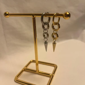 Chunky örhängen med kedjor och spikes - Säljer ett par coola örhängen med chunky ringar och kedjor i både silver och guld. Varje örhänge har en spetsig spike längst ner som ger en edgy vibe. Perfekt för dig som gillar att sticka ut med din stil.
