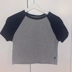 Grå och svart croppad t-shirt Superdry - Croppad t-shirt från Superdry med grå kropp och gråa ärmar. Mycket bra skick! I storlek XL men passar storlek S/M utmärkt!