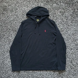 Svart tröja - Polo Ralph Lauren - Säljer denna svarta tröja/kofta med luva på. Den är i mycket bra skick! Använt den 2-3 gånger men inte mer än det. Använt den väldigt försiktigt samt hållbart. Säljs pga den är liten för mig. Har ni några frågor är det bara hojta till! Ny pris cirka 1100kr.