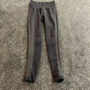 Svarta leggings från Craft XS - Säljer ett par svarta leggings från Craft i storlek XS. De har höga ribbade midjor och tunna vita ränder längs benen. Materialet är en mix av nylon, polyester och elastan vilket gör dem riktigt sköna och stretchiga. Perfekta för träning eller chill. Litet hål på baksidan❤️