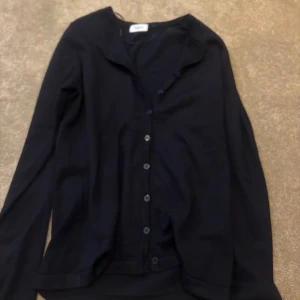 Svart kofta med knappar  - Snygg svart kofta från saint tropez med långa ärmar och knappar hela vägen framtill. passar till allt. Enkel och stilren design 
