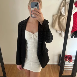 Svart kavaj från SHEIN - Svart kavaj från SHEIN i storlek XS. Klassisk modell med krage och två fickor framtill. Snygg, enkel och passar till många olika looks. Materialet är mjukt och lätt, perfekt för dig som gillar stilrena plagg.