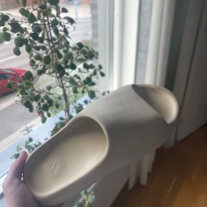Yeezy slide ”Bone” strl 43 - Yezzy slides i färgen ”Bone” i storlek 43. Tofflorna är väldigt små i storleken så de passar storlek 40-41  Köpte dom på PardonMyKicks för 2 599kr, mitt pris 1299kr  Kan tänka mig att gå ner i pris vid snabb affär