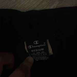 Svarta shorts från Champion M - Svarta shorts från Champion i storlek medium. Klassisk loose passform med elastisk midja för skön komfort. Perfekta för träning eller chill dagar. Materialet känns mjukt och lätt, vilket gör dem riktigt bekväma att ha på sig.