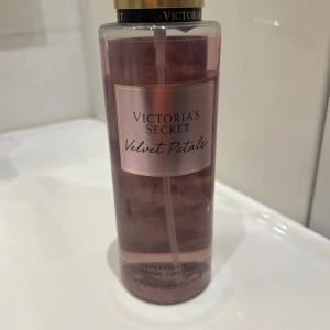 Victoria's Secret Velvet Petals mist - Fräsch och feminin body mist från Victoria's Secret i doften Velvet Petals. Kommer i en genomskinlig plastflaska med rosa vätska och guldfärgad spraykork. Doften har inslag av blommor och mandel, nästan helt oanvänd. 