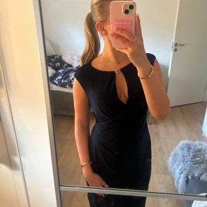 Marinblå finklänning från Ralph lauren  - Snygg mörkblå klänning från Ralph lauren med nyckelhålsöppning framtill och guldfärgad detalj vid halsen. Klänningen är knälång, har ärmlös design och markerad midja som ger en smickrande siluett. Perfekt för dig som gillar stilrena och eleganta plagg. Aldrig använd 💗 Storlek 8 som motsvarar storlek 40 men passar mig som är storlek S 💕