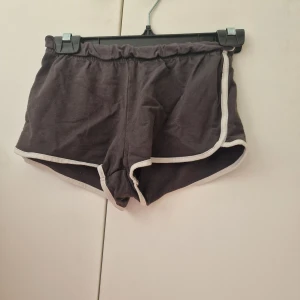 Svarta mjukia shorts från H&M - Svarta mjukis shorts från H&M med vit kant längs benen. De har elastisk midja. Storlek 152
