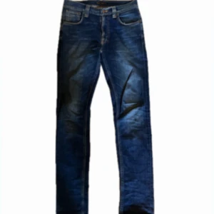 Nudie Jeans Lean Dean blå jeans - Snygga Nudie Jeans Lean Dean i färgen Bay Blue. Jeansen har klassisk femficksdesign, orangea sömmar och raka ben med en slim passform. Tillverkade av 98% ekologisk bomull och 2% elastan för extra komfort. Perfekta för dig som gillar stilrena och tidlösa jeans. Tveka inte på att höra av er vid frågor!