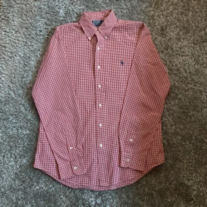 Ralph lauren skjorta - Säljer en rosa och vit rutig skjorta från Polo Ralph Lauren i custom fit. I skick som ny utan några defekter! Hojta till om du har någon fråga!