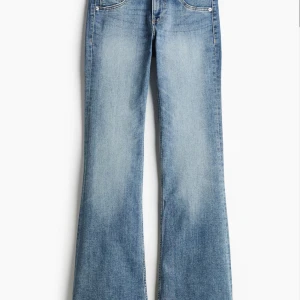 Bootcut jeans i ljusblå denim - Snygga bootcut jeans i ljusblå tvättad denim med klassisk femficksdesign. Jeansen har en hög midja och raka ben som blir vidare nedtill. Perfekta för dig som gillar retrovibbar och vill ha en avslappnad men trendig look.