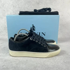 Lanvin DBB1 cap toe sneaker - – Condition: 8,5/10  - Size: 39/UK5  – What is included: dustbag  – Retail price: 5000 + SEK  Please note that Lanvins fit big and our recommendation is to go one size down