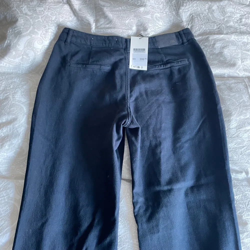 Snygga svarta byxor från Zara med en klassisk design. De har en rak passform och är tillverkade i ett bekvämt material. Perfekta för en stilren look.. Farkut & Housut.