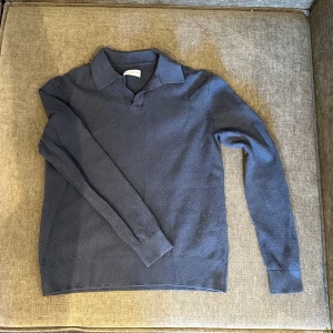 Blå tröja från These Glory Days - Säljer en stilren blå tröja från These Glory Days. Tröjan har en klassisk krage och är långärmad med ribbade muddar. Perfekt för en avslappnad men ändå snygg look. Använd 1 gång