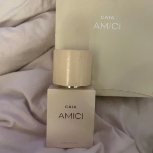 Parfym CAIA AMICI  - Elegant parfym från CAIA med namnet AMICI. Flaskan har en stilren design i beige med ett matchande lock. Perfekt för den som söker en fräsch doft.
