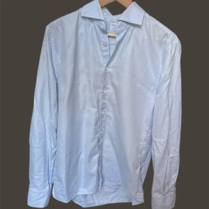 Stenströms skjorta - Snygg ljusblå skjorta med klassisk krage och knappar framtill. Perfekt för en stilren look. Skjortan har långa ärmar och är tillverkad i ett lätt och bekvämt material.