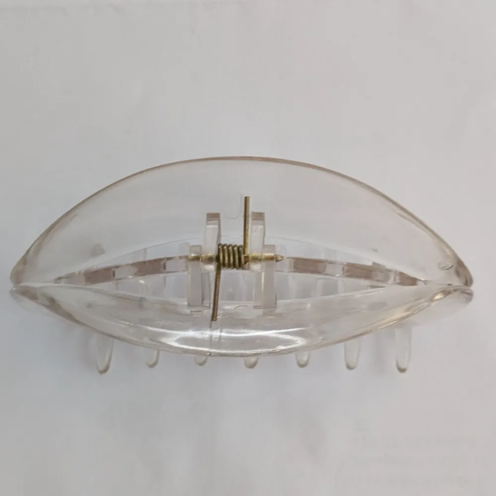 Säljer en stilren och transparent hårklämma i plast. Perfekt för att enkelt sätta upp håret med stil. Klämman har en klassisk design med en stark fjäder för bra grepp.. Asusteet.