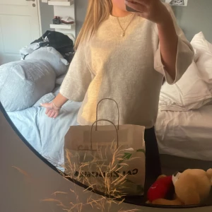 Vit stickad tröja - Säljer en mysig vit stickad tröja med trekvartsärm. Perfekt för kyligare dagar och enkel att matcha med olika outfits. Tröjan har en rund halsringning och en avslappnad passform. Aldrig använd