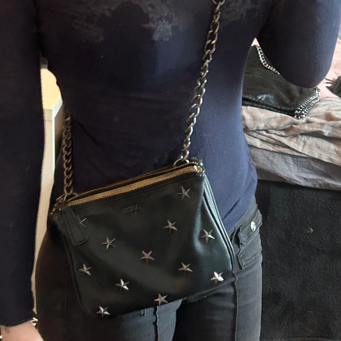 Svart axelväska med stjärndetaljer från Guess